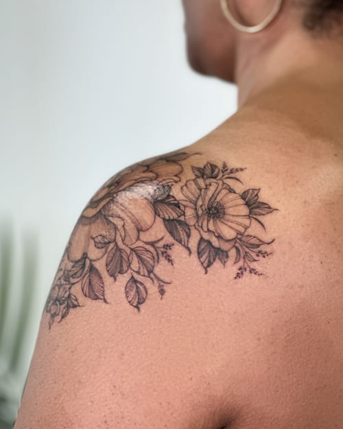 A delicate black and grey floral bouquet tattoo on the shoulder with fine line detailing — by Melanie Benoit, los angeles