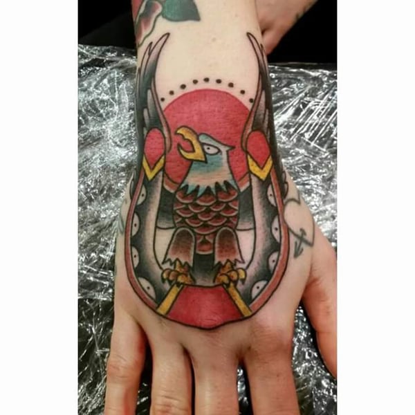 A bold American Traditional eagle tattoo on the hand with vibrant colors — by Samuel Connelly, san diego, ca