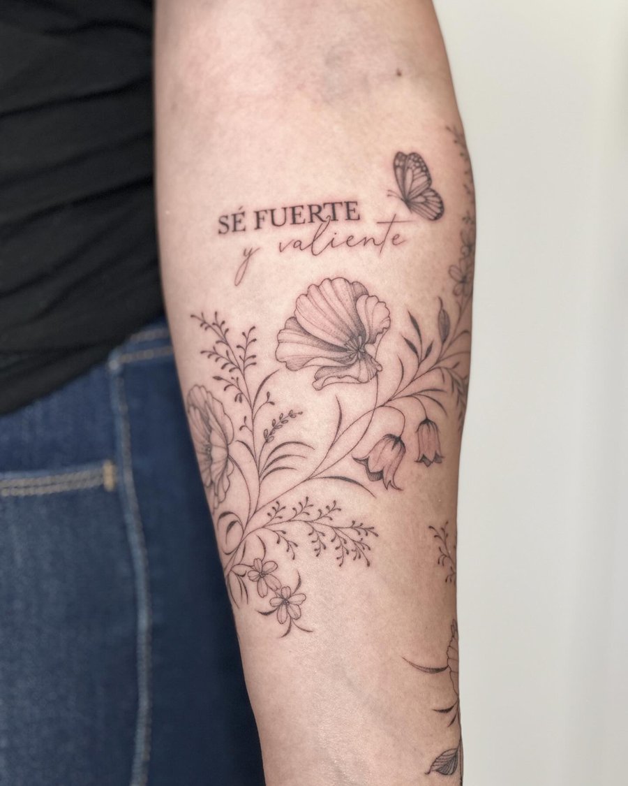 A delicate black and grey floral design with script lettering and a butterfly on the forearm — by Melanie Benoit, los angeles