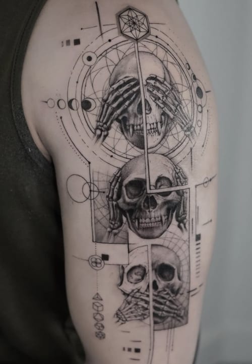 A black and grey geometric tattoo featuring three skulls with hands covering their eyes, ears, and mouth, surrounded by intricate geometric patterns on the upper arm — by Jian Liang, los angeles