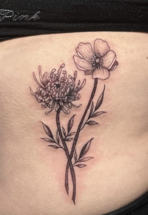 A fine line black and grey tattoo of two flowers with delicate leaves on the rib, showcasing intricate linework and shading — by Shelby Bianco, los angeles