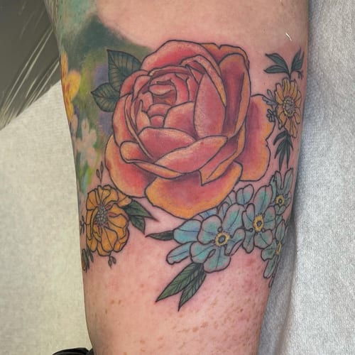 A colorful neo-traditional rose bouquet tattoo on the arm with bold outlines and vibrant colors — by Sandra Price, los angeles