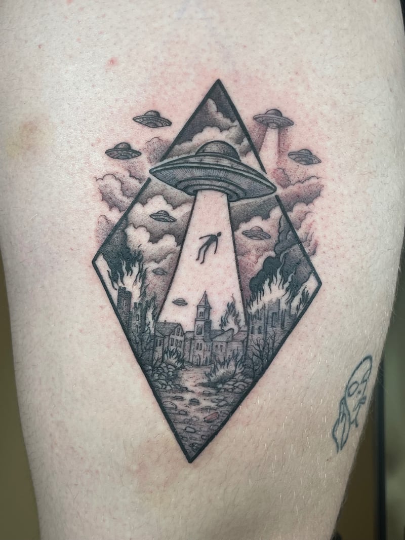 surrealist black and grey tattoo of a ufo abducting a figure over a burning town inside a diamond frame by Vince Espinoza, a surrealism tattoo artist in los angeles
