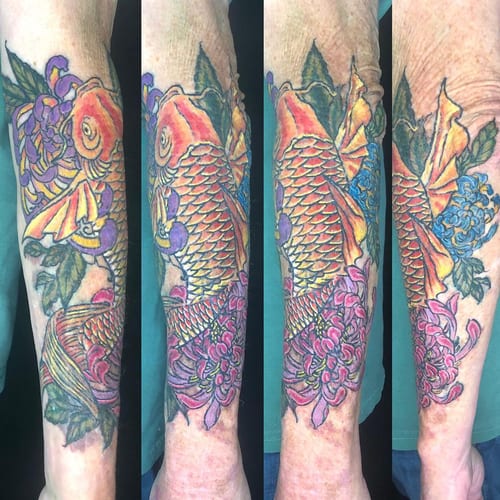 A colorful Japanese-style koi fish and floral tattoo on the forearm, featuring bold and ornate designs — by Sandra Price, los angeles