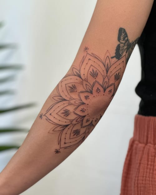 A delicate black and grey mandala tattoo on the forearm with intricate linework and dot detailing — by Melanie Benoit, los angeles