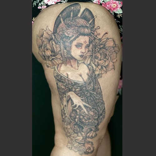 A detailed black and grey tattoo of a geisha with flowers on the thigh, featuring intricate patterns and delicate shading — by Sandra Price, los angeles