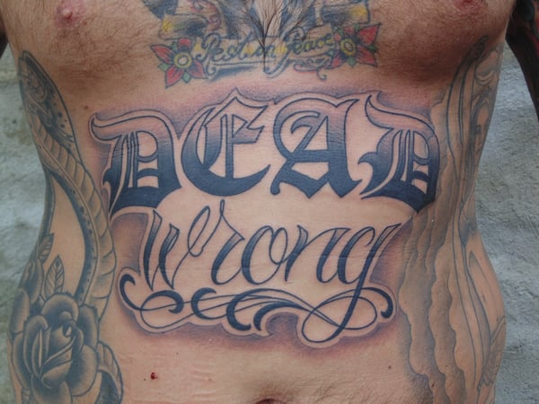 Bold black and grey script lettering tattoo on the stomach — by Samuel Connelly, san diego, ca