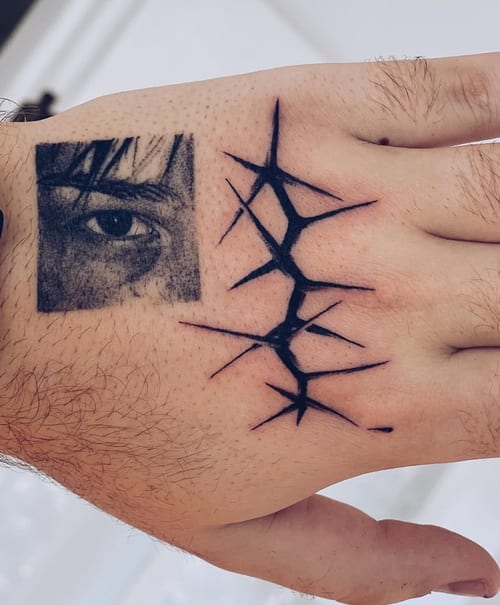 A minimalist blackwork tattoo on the hand featuring a detailed eye and abstract linework — by Level tattoo, los angeles