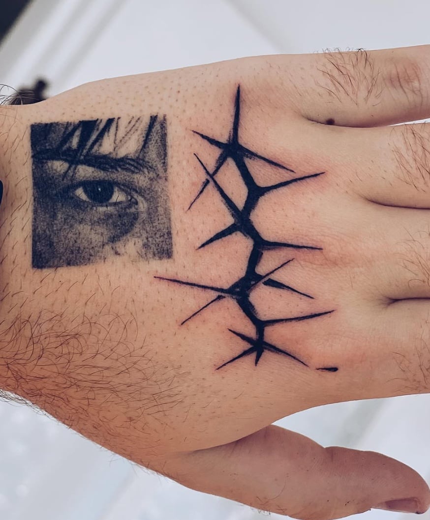 A minimalist blackwork tattoo on the hand featuring a detailed eye and abstract linework — by Level tattoo, los angeles