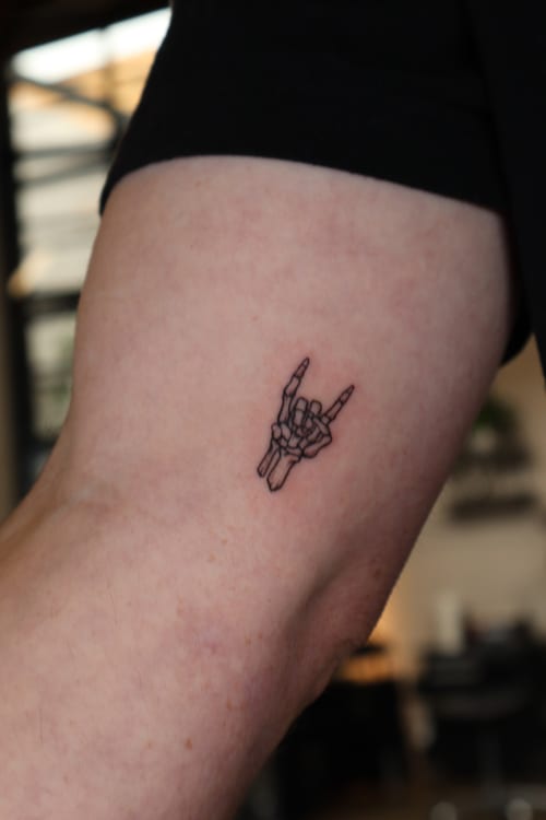 minimalist hand making rock gesture tattoo — by Vince Espinoza, los angeles