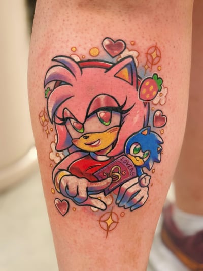 A colorful tattoo of Amy Rose from the Sonic series on the calf, featuring a vibrant pop art style with hearts and strawberries — by Tweetwee, los angeles