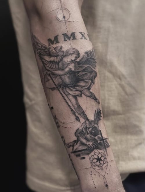 A black and grey realism tattoo on the forearm depicting an angel with detailed shading and geometric elements — by Jian Liang, los angeles