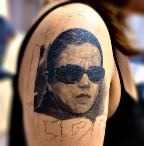 A black and grey realism portrait of a woman wearing sunglasses on the upper arm, with detailed shading and texture — by 钟逸政, los angeles