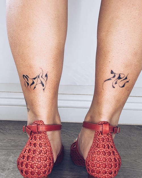 A minimal black script lettering tattoo on the calf, featuring stylized text in a blackwork style — by Level tattoo, los angeles