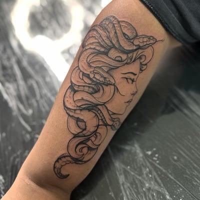 A black and grey Medusa tattoo on the forearm with fine line details and snake hair — by Maddie Ramirez, los angeles