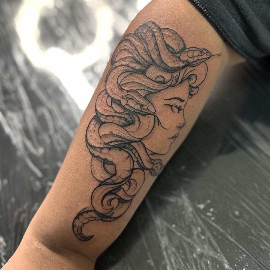 A black and grey Medusa tattoo on the forearm with fine line details and snake hair — by Maddie Ramirez, los angeles