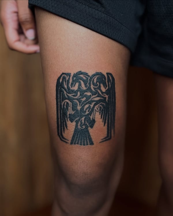 A bold blackwork tribal eagle tattoo on the thigh with intricate patterns and strong lines — by Dylan Aiello, los angeles