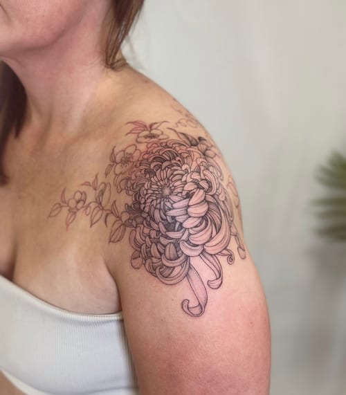 A delicate black and grey chrysanthemum flower tattoo on the shoulder with fine line detailing — by Melanie Benoit, los angeles
