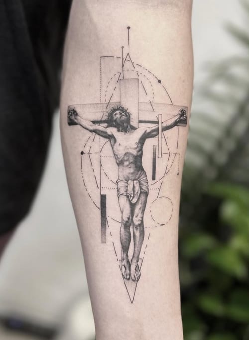 A black and grey realism tattoo of Jesus Christ on the cross with geometric elements on the forearm, featuring detailed shading and linework — by Jian Liang, los angeles
