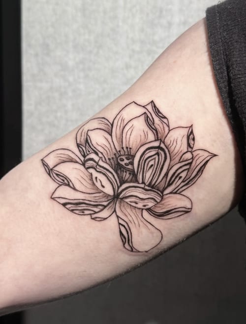A minimalist black and grey linework tattoo of a flower on the arm, featuring clean lines and simple design — by Shelby Bianco, los angeles