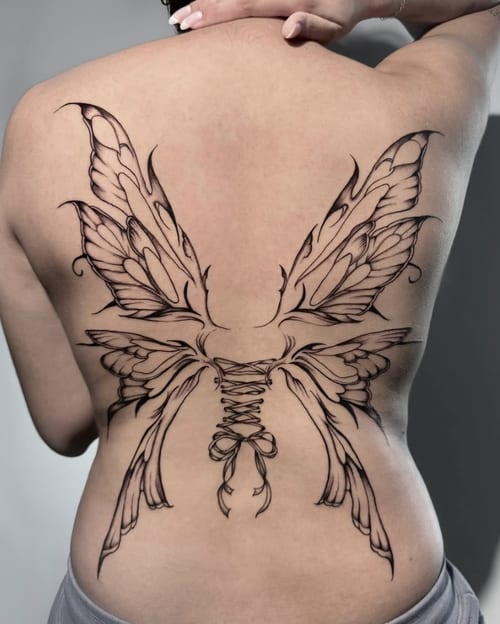 A large black and grey linework tattoo of butterfly wings on the back, featuring intricate detailing and symmetrical design — by Shelby Bianco, los angeles