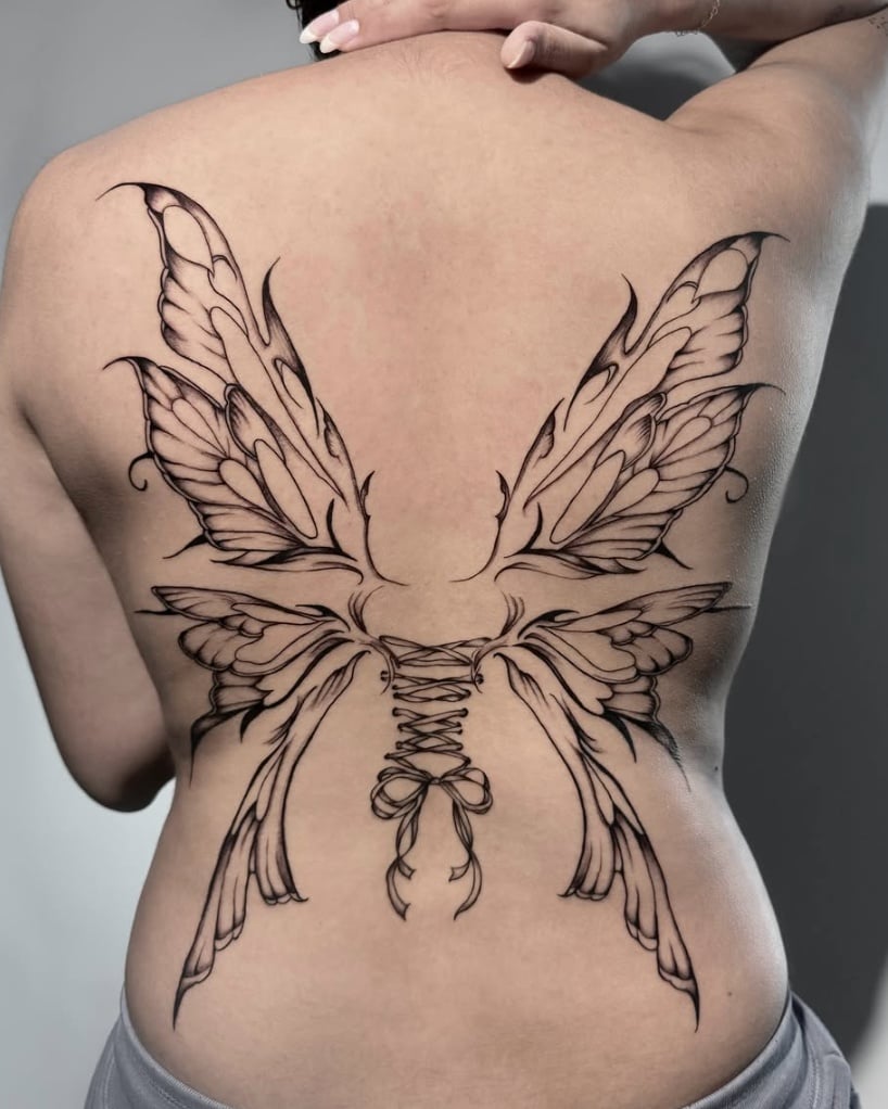 A large black and grey linework tattoo of butterfly wings on the back, featuring intricate detailing and symmetrical design — by Shelby Bianco, los angeles