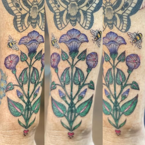 A colorful traditional flower bouquet with bees on the forearm, featuring delicate and whimsical details — by Sandra Price, los angeles