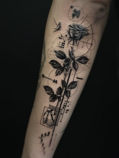 A black and grey geometric and illustrative tattoo on the forearm featuring a rose with intricate linework and abstract elements — by Jian Liang, los angeles
