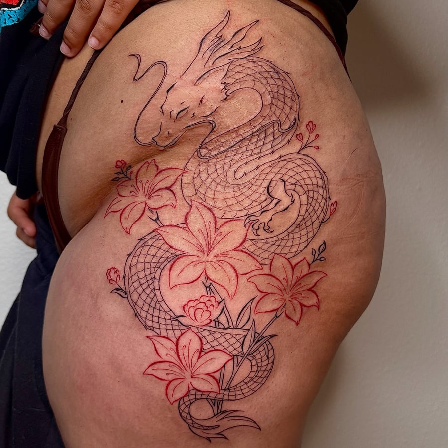 A Japanese-style dragon with flowers tattoo on the thigh, featuring intricate linework and a mixed color profile — by NJ TATTOOZ, los angeles