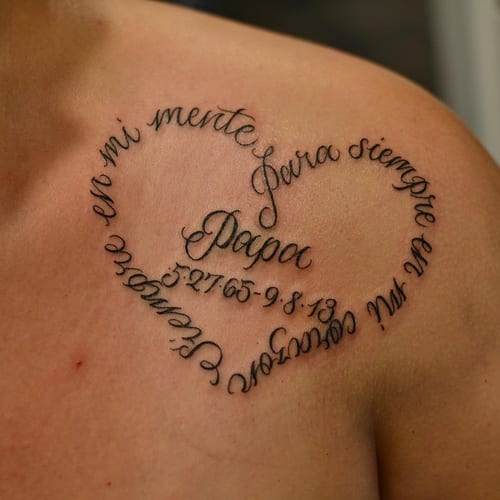 A delicate black script lettering tattoo on the shoulder, forming a heart shape with a memorial quote — by Johnny Ayala, los angeles