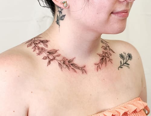 A delicate black and grey floral collar tattoo on the neck with fine line detailing — by Melanie Benoit, los angeles