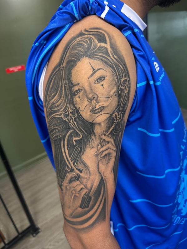 A black and grey Chicano style portrait of a woman on the upper arm, featuring fine line details and smooth shading — by Humilde tattoos, los angeles
