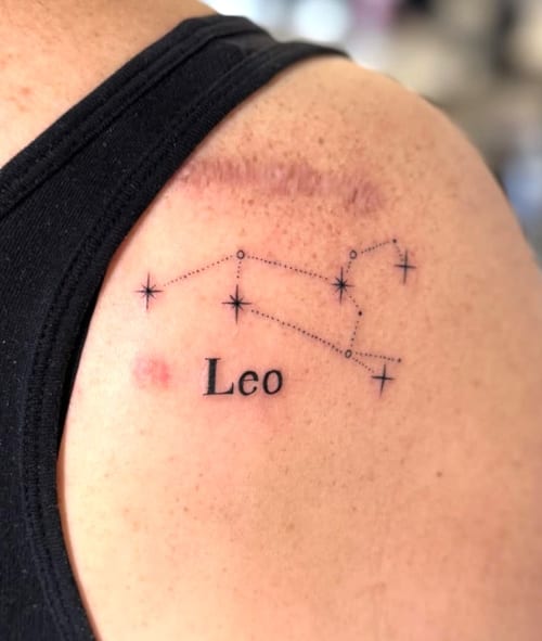 A minimalist black and grey tattoo of the Leo constellation with fine lines and the word 'Leo' on the shoulder — by otaybeatdown, los angeles