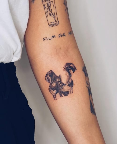 An abstract black and grey tattoo on the forearm, featuring a stylized, artistic design with bold black ink — by Level tattoo, los angeles