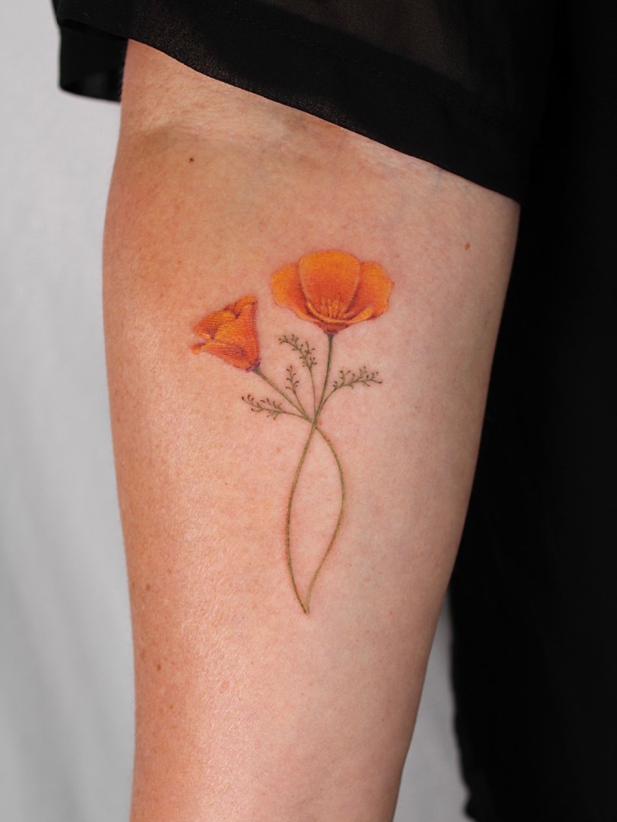A delicate color tattoo of poppy flowers on the forearm, featuring fine line botanical details — by Melanie Benoit, los angeles