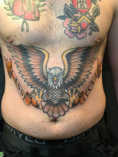 A bold American Traditional eagle tattoo with a banner across the stomach — by Samuel Connelly, los angeles