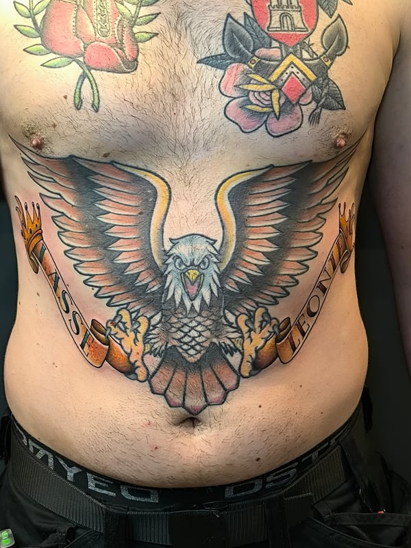 A bold American Traditional eagle tattoo with a banner across the stomach — by Samuel Connelly, san diego, ca