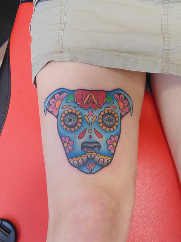 A colorful sugar skull dog tattoo on the thigh with bold illustrative style — by Samuel Connelly, san diego, ca