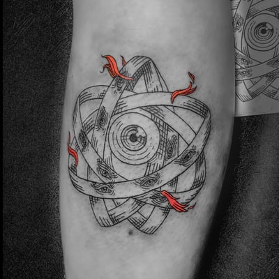 A surreal blackwork tattoo on the forearm featuring an intricate design of eyes within a circular pattern, accented with red flames — by Tag Devilish, los angeles