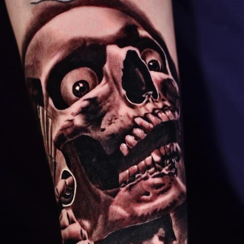 A realistic black and grey skull tattoo on the forearm with intense shading and graphic details — by Johnny Ayala, los angeles