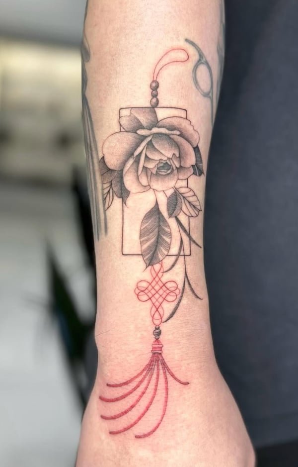 A mixed color ornamental tattoo on the forearm featuring a black and grey floral design with red decorative elements — by otaybeatdown, orange, ca