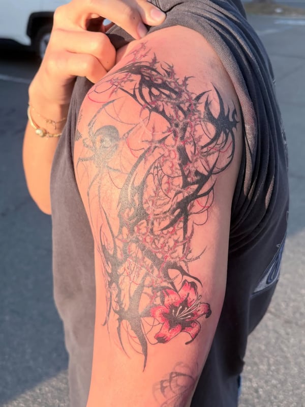 An abstract tribal design with a red flower on the upper arm, featuring bold black lines and graphic elements — by Hannah , fountain valley, ca