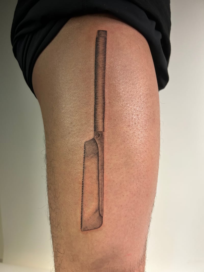 black and grey realism tattoo of a cleaver with a wrapped handle by Brian Kies, a black and grey realism tattoo artist in highland park, los angeles