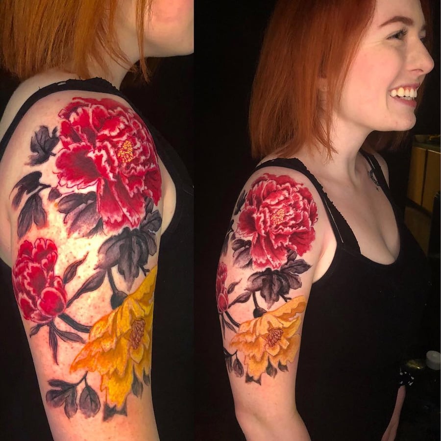 A vibrant neo-traditional tattoo of red and yellow peony flowers on the upper arm, featuring bold colors and ornate details — by Sandra Price, los angeles