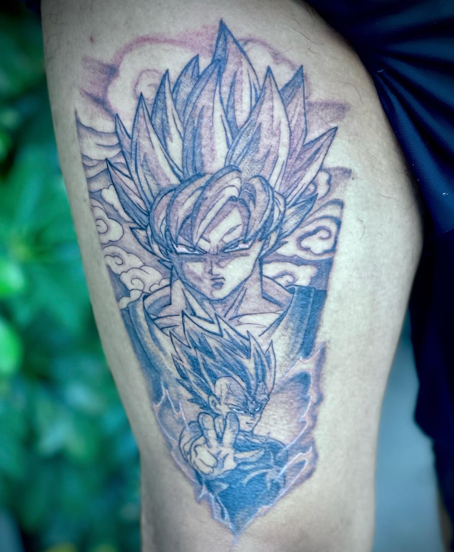 A black and grey tattoo of Goku from Dragon Ball Z on the thigh, featuring bold anime styling and dynamic shading — by Sandra Price, los angeles
