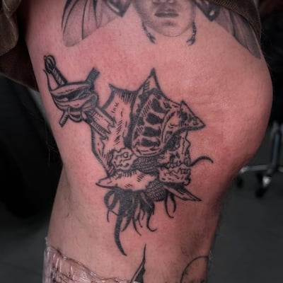 A bold blackwork tattoo of a sword and helmet on the leg, featuring illustrative details and strong lines — by Hannah , los angeles