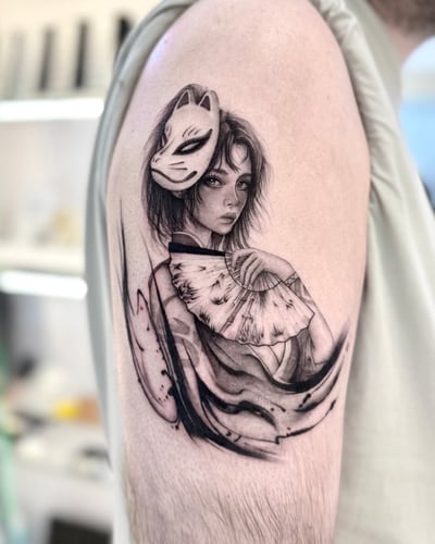 A black and grey realistic tattoo of a woman holding a fan, with a mask on her head, located on the upper arm — by otaybeatdown, los angeles
