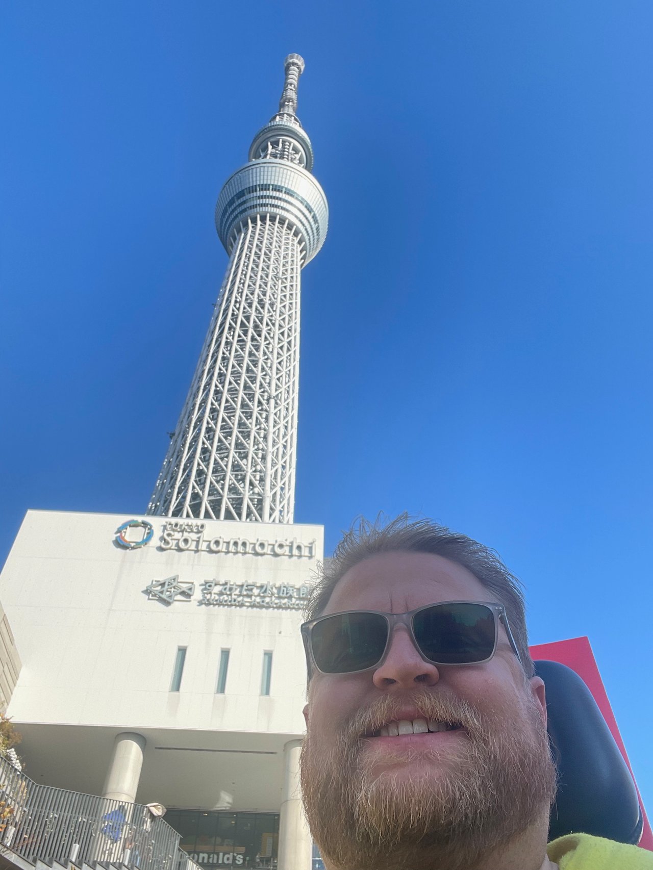 Adam smiling with Tokyo Skytree in the background during the go kart tour