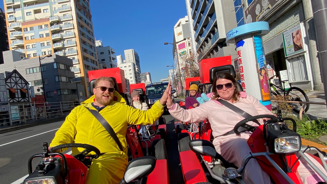 Adam and Lindsay riding go karts together through Tokyo streets in costume