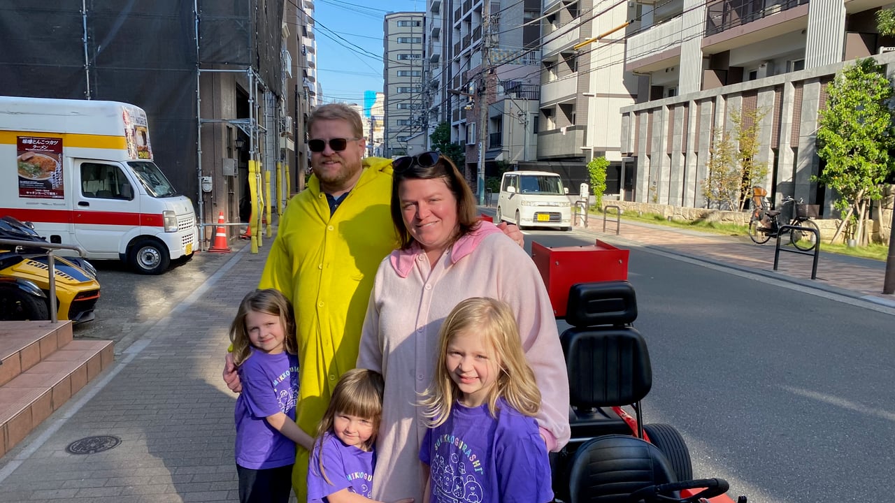Family posing on a Tokyo street before starting the go kart tour